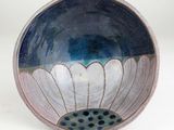 a blue and white bowl with a flower inside of it