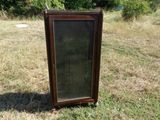 une vieille armoire en bois posée au milieu d'un champ
