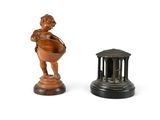une petite statue représentant un garçon tenant un bol, à côté d'une petite statue représentant une femme