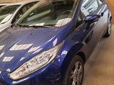 two blue cars parked next to each other in a garage