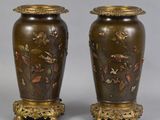 pair of bronze vases with birds and flowers on them