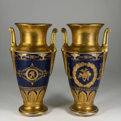 pair of blue and gold vases sitting on top of a white table