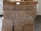 une grande pile de cartons posée sur une palette dans un garage