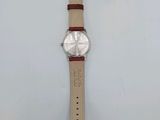 a close up of a watch on a white surface with a tag