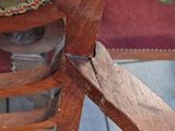 a close up of a wooden chair with a glass on it