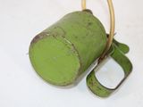 a green cup with a handle on a white table