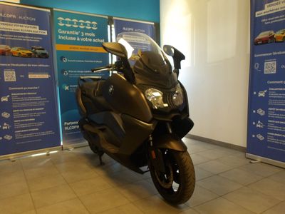 une moto noire garée devant un mur bleu