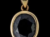 un gros plan d'un pendentif en diamant noir sur fond noir