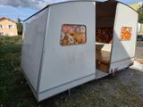 a small trailer with a bed in the back of it
