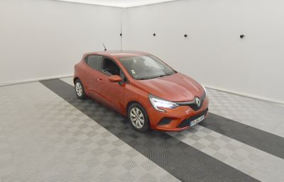 the orange car is parked in the garage on the checkered floor