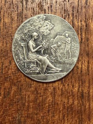 an old silver coin sitting on top of a wooden table