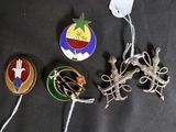 several pins and badges are laying on a black surface