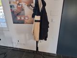 a coat rack in the corner of a room with clothes on it