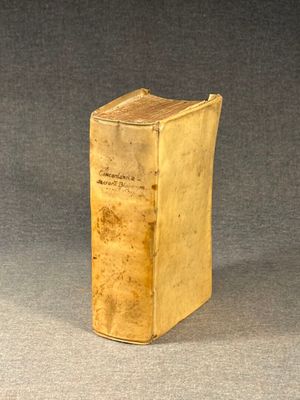 an old book sitting on top of a table on a gray surface