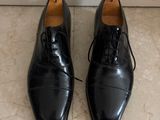 a pair of black shoes sitting on top of a tiled floor