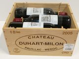 bottles of red wine in a wooden crate on a white surface