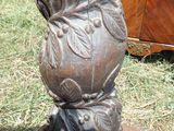un vase posé sur un socle dans l'herbe
