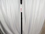 un bâton noir muni d'un manche vert, posé sur un drap blanc