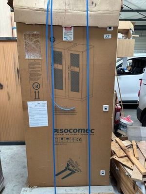 un grand carton posé au sommet d'un tas de bois