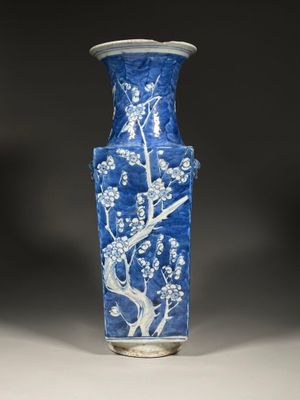 a blue and white vase with a tree design on it