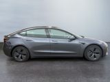 the tesla model 3 is parked in a parking lot