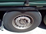 a green truck that has a flat tire on the side of it