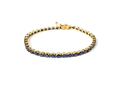 un bracelet en or serti de saphirs bleus