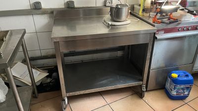 une table en acier inoxydable sur laquelle est posée une casserole dans une cuisine