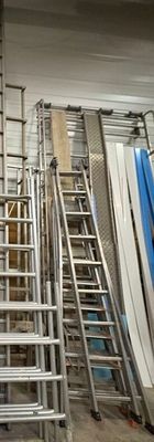 de nombreuses échelles métalliques dans une pièce comportant de nombreuses étagères
