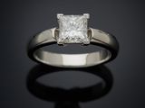 une bague de fiançailles ornée d'un diamant taille princesse sur fond noir