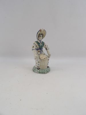 une figurine représentant une femme avec un panier de fleurs