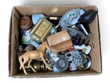 une boîte en carton remplie d'objets divers posée sur une surface blanche