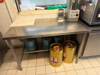 une cuisine équipée d'une table en inox sur laquelle se trouve un micro-ondes