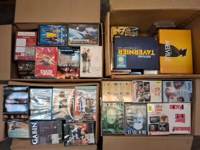 un grand nombre de dvd dans une boîte posée sur le sol
