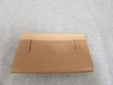 a tan leather wallet sitting on top of a gray cloth