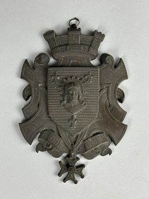 une plaque métallique sur laquelle figurent des armoiries et une couronne