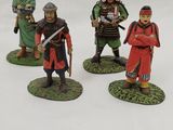 three figurines of men dressed in medieval clothing and holding swords