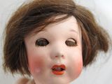 a close up of a doll with a red lipstick on it