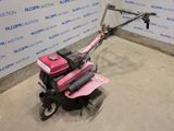 a small pink lawn mower sitting in a room