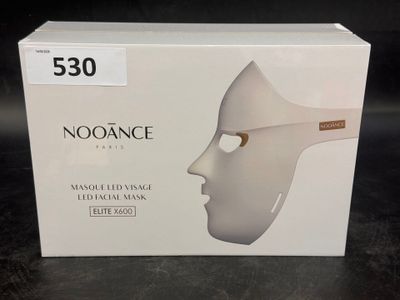une boîte sur laquelle est représenté un masque blanc, posée sur une table