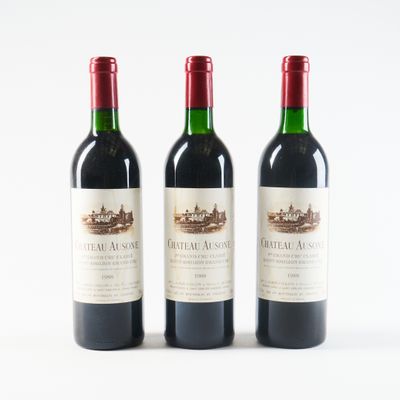 trois bouteilles de vin rouge posées l'une à côté de l'autre sur une surface blanche