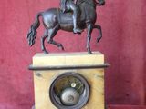 bronze statue of a man on a horse on a marble base