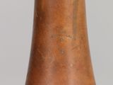 a brown vase with writing on it sitting on a table
