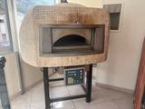 une photo d'un four à pizza au feu de bois dans une cuisine