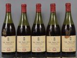 six bottles of wine are lined up in a row on a table