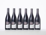 six bottles of wine lined up in a row on a table