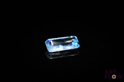 a close up of a blue topazte stone on a black surface