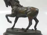 bronze statue of a horse on a wooden base on a white background