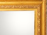 an image of a gold framed mirror on a white wall