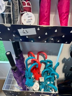 un présentoir de parapluies et d'autres articles dans un magasin